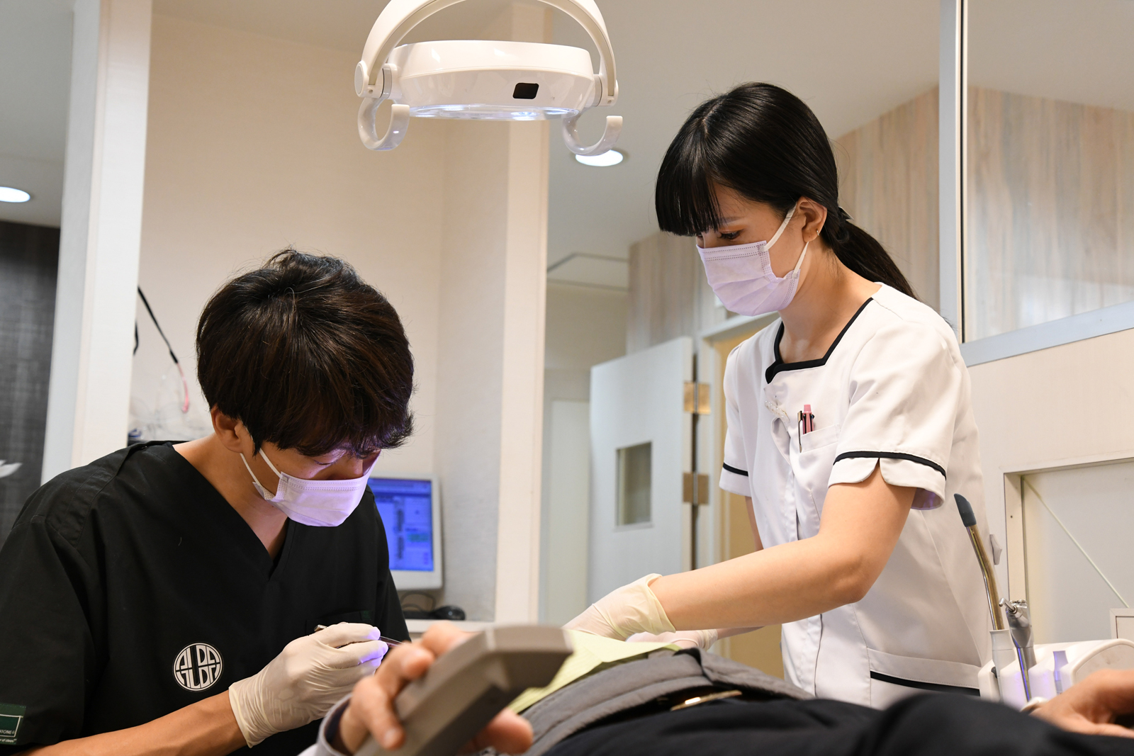 歯のクリーニングをする歯科医師と歯科衛生士の写真です