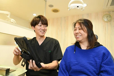 審美セラミックについて説明をする歯科医師と説明を受ける患者/治療について説明する歯科医師