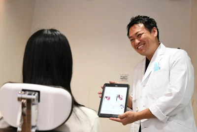 ボロボロの歯の治療について説明する歯科医師/セラミック治療について説明する歯科医師